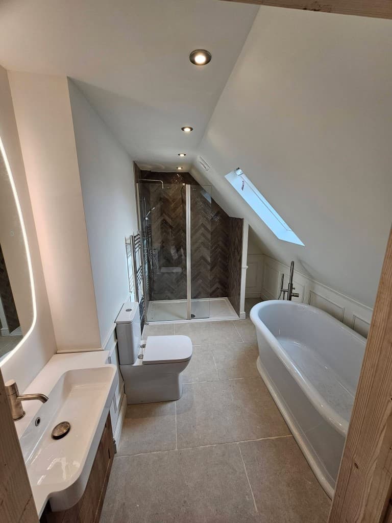 Attic bathroom with frameless glass shower and freestanding bath